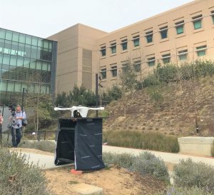 Drone on black stand at UC San DIego in front of large building